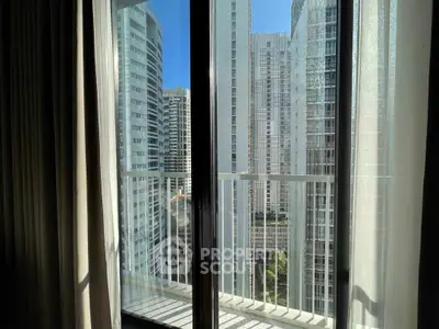 Stunning cityscape view from a modern apartment balcony with tall glass doors.