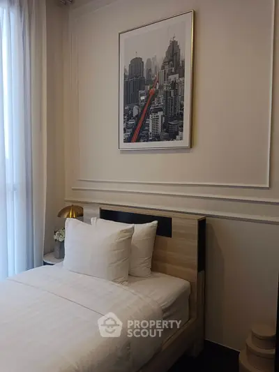 Cozy bedroom with modern decor and cityscape artwork, featuring a comfortable bed and soft lighting.