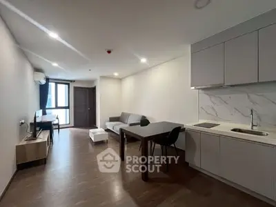 Modern open-plan living room with sleek kitchen and stylish furnishings.