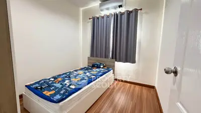 Cozy bedroom with wooden flooring and modern air conditioning unit, perfect for a comfortable living experience.