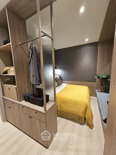 Modern bedroom with stylish wooden storage and cozy yellow blanket