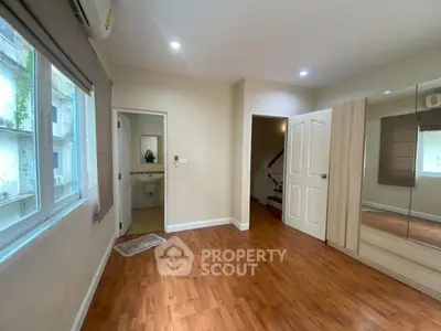 Spacious bedroom with wooden flooring and built-in wardrobe