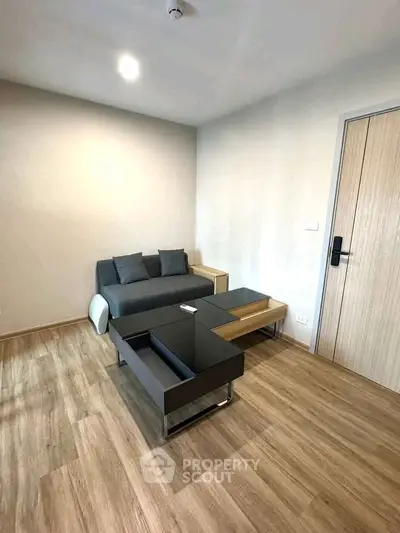 Modern living room with sleek furniture and wooden flooring in a cozy apartment.
