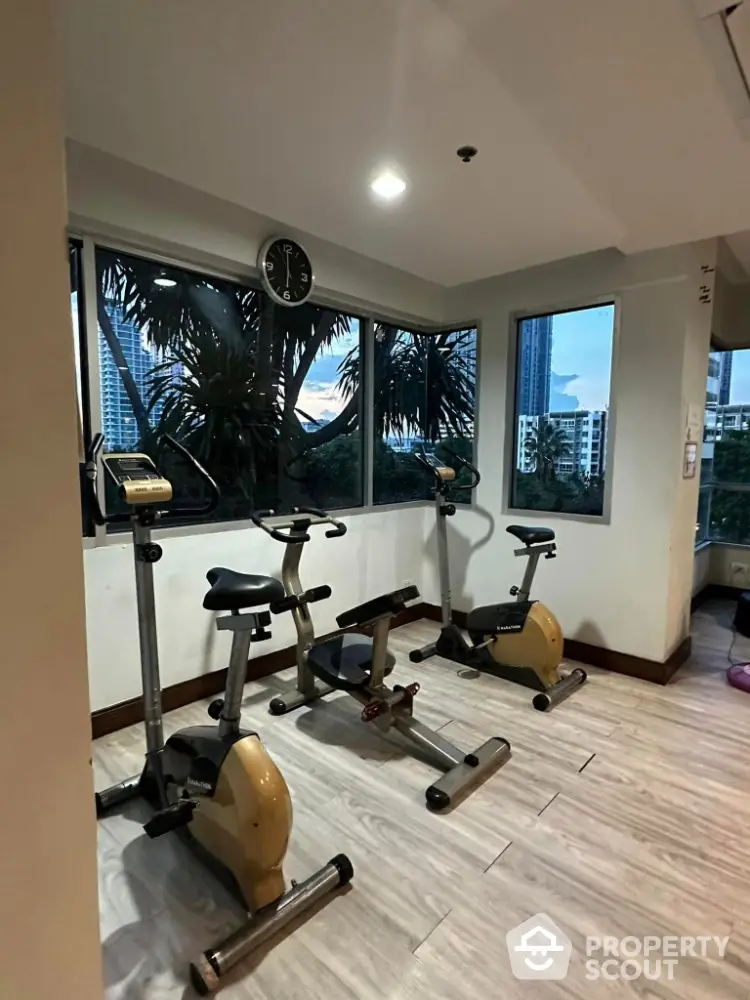 Modern gym with exercise bikes and city view, perfect for fitness enthusiasts.