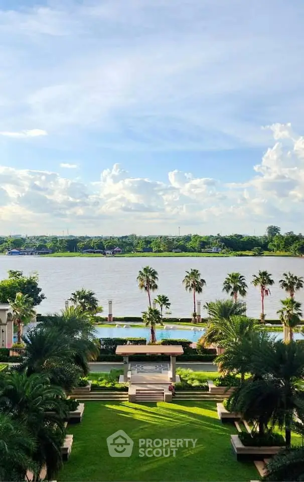 Stunning riverfront view with lush gardens and palm trees, perfect for luxury living.