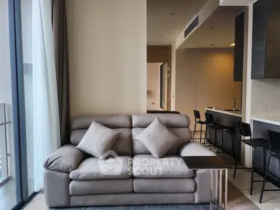 Modern living room with plush sofa and sleek kitchen in open layout apartment
