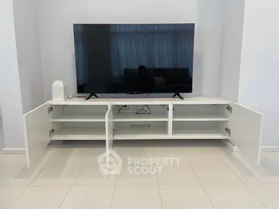 Modern living room with sleek white TV stand and large flat-screen TV