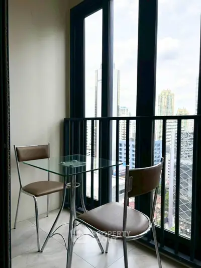 Chic urban balcony with glass table and city skyline view, perfect for modern living.