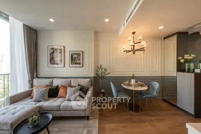 Elegant living room with chic decor and dining area, featuring stylish lighting and cozy seating.