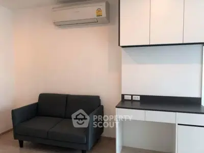 Modern living room with sleek black sofa and built-in storage under air conditioning unit.