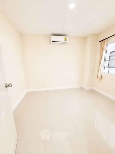 Spacious empty room with air conditioning and tiled floor, perfect for customization.