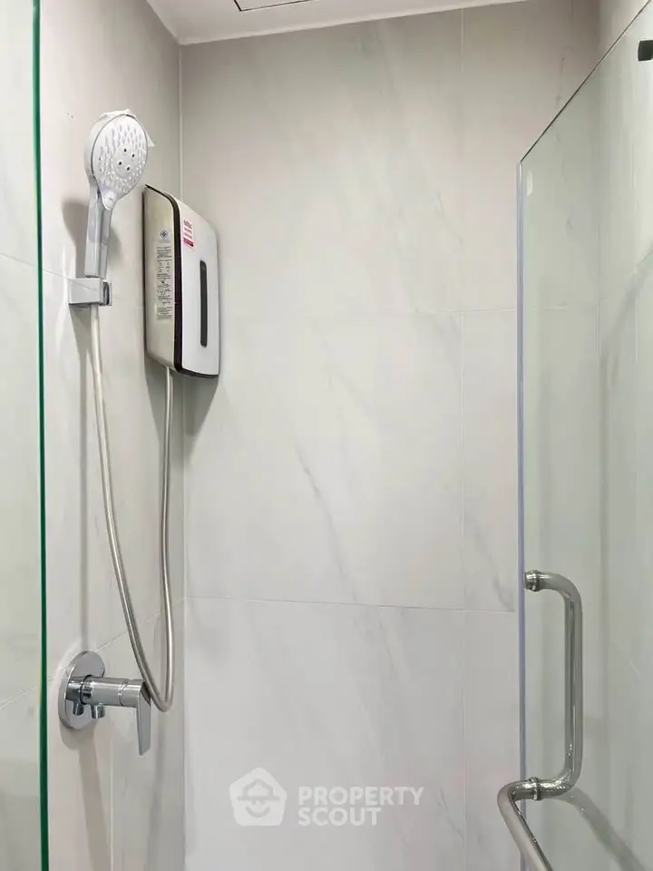 Modern bathroom shower area with glass partition and sleek fixtures