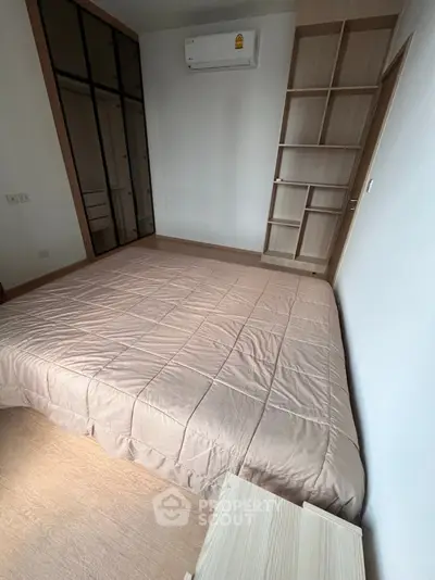 Cozy bedroom with modern design, featuring built-in shelves and air conditioning for ultimate comfort.
