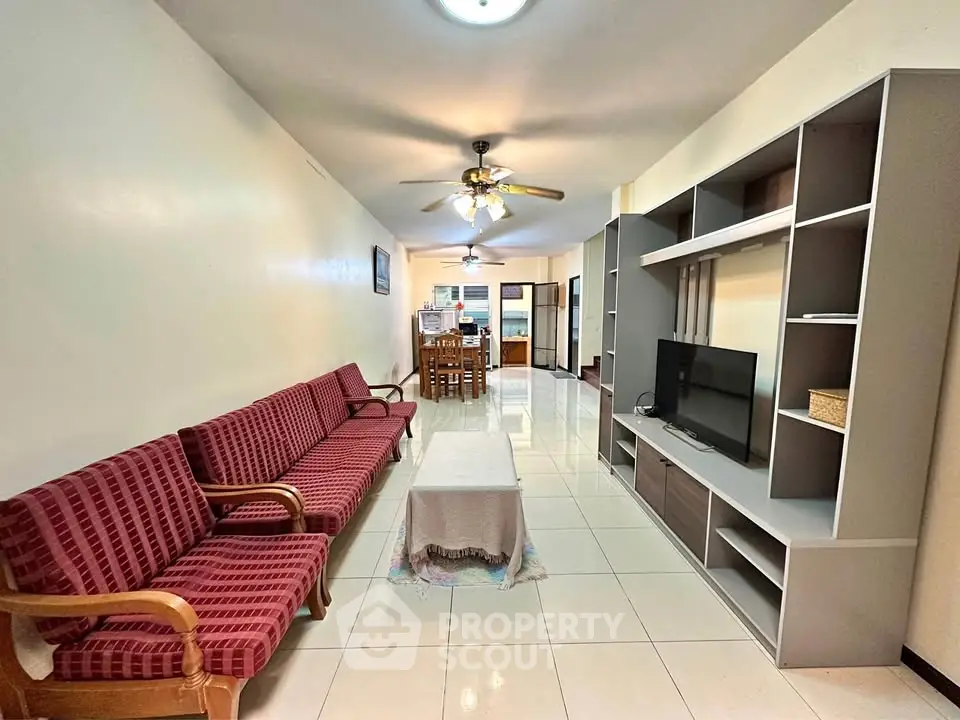 Spacious living room with modern furniture and open layout in a cozy apartment.