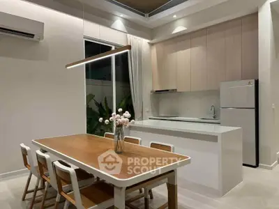 Modern kitchen and dining area with sleek design and elegant lighting