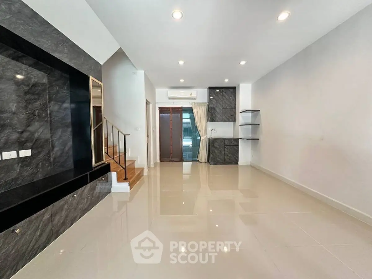 Spacious modern living room with sleek design and elegant staircase