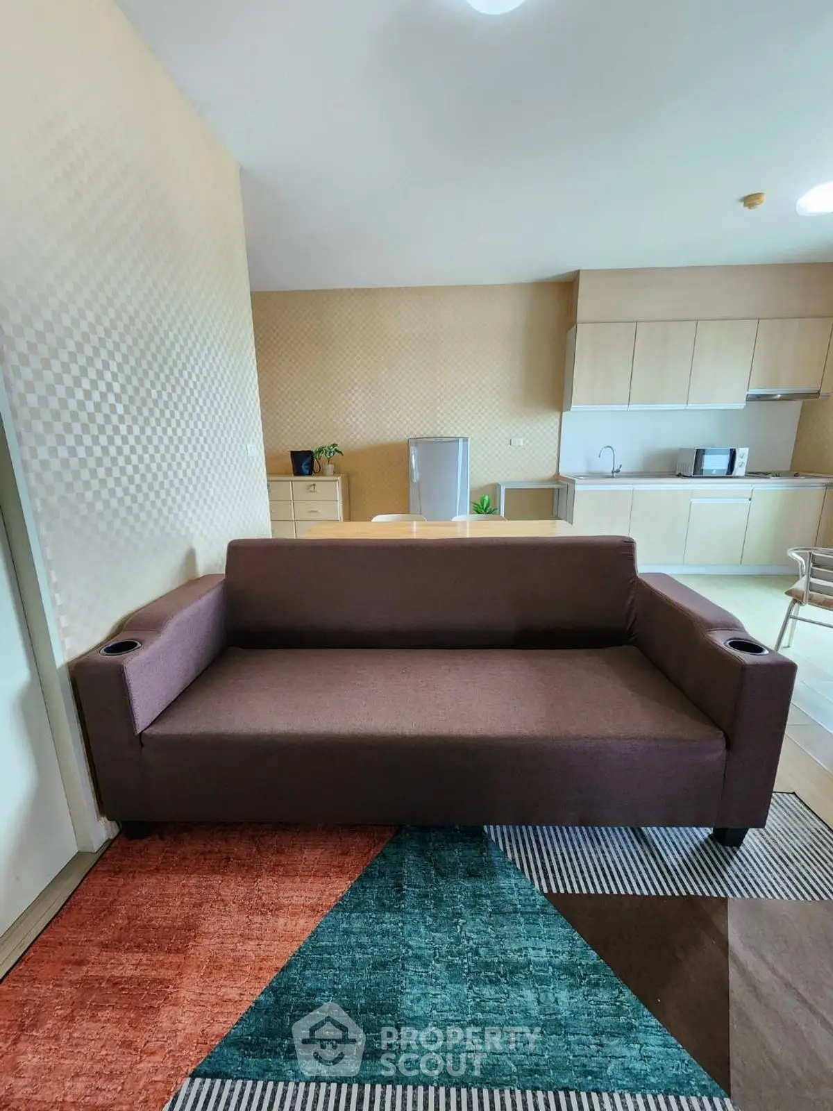 Spacious living room with modern sofa and open kitchen layout