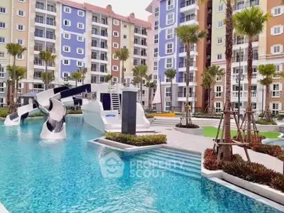 Vibrant apartment complex with colorful buildings and a luxurious pool featuring water slides.