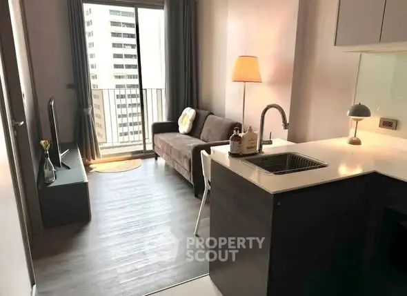 Modern living room with open kitchen and balcony view in urban apartment