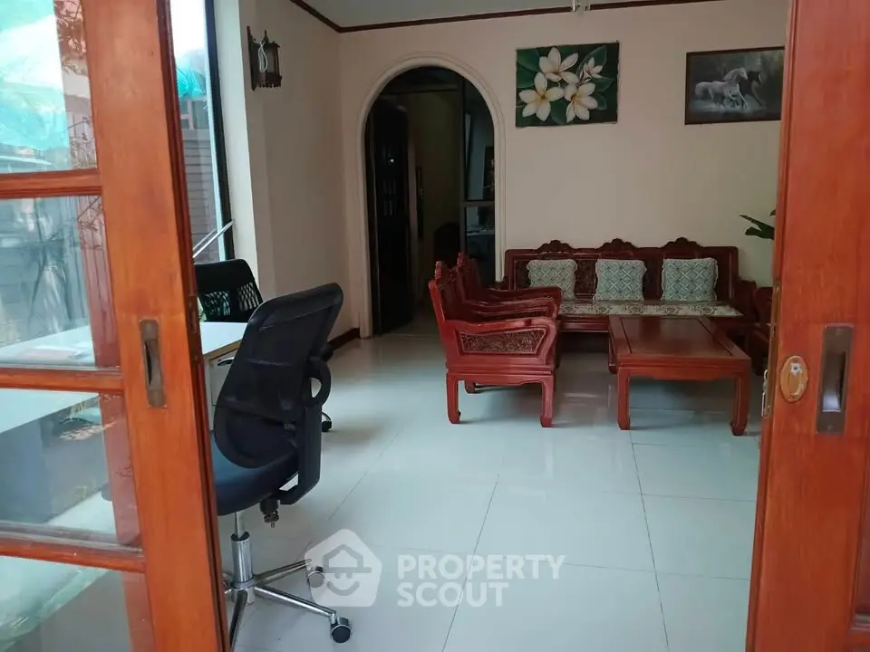 Charming living room with elegant wooden furniture and natural light, perfect for relaxation and entertaining.