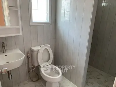 Modern bathroom with sleek tiles and compact fixtures, perfect for urban living.