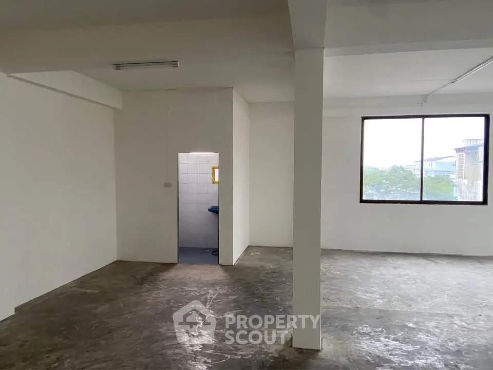 Spacious open-plan interior with large window and minimalist design, perfect for customization.