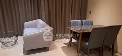 Modern living room with stylish sofa and dining table, elegant curtains, and chic decor.
