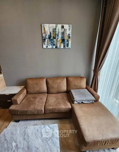 Cozy living room with brown sectional sofa and abstract art on wall, perfect for relaxation.