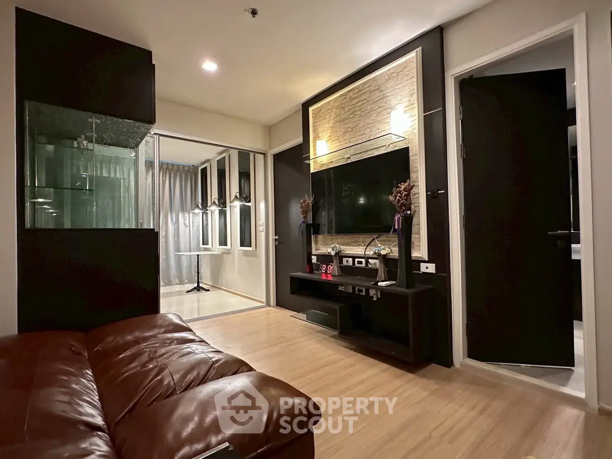 Modern living room with sleek design, featuring a large TV, stylish lighting, and comfortable seating.