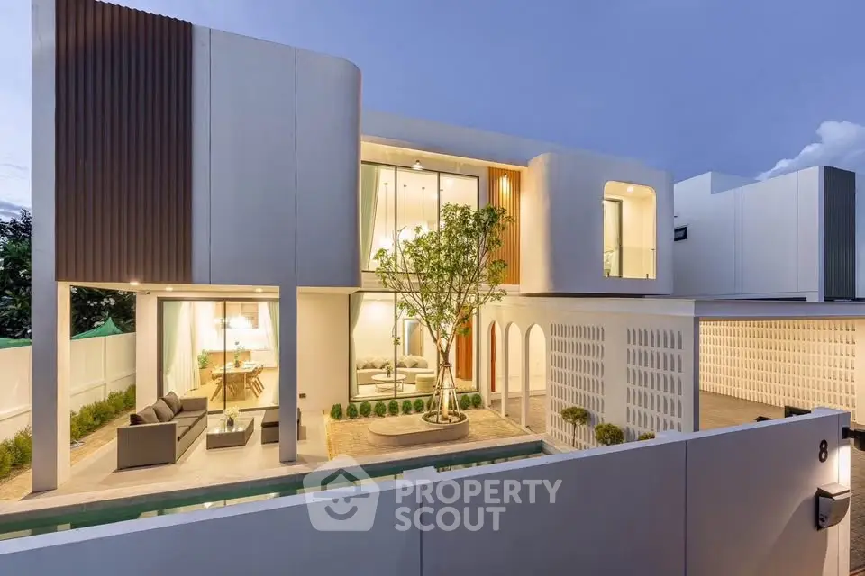 Modern luxury home exterior with sleek design and spacious outdoor living area at dusk.