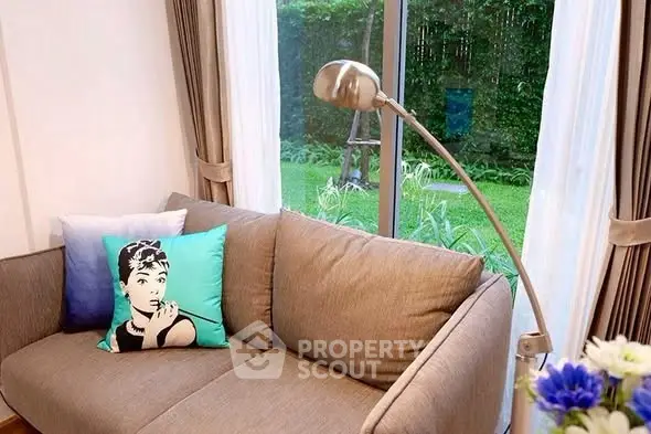 Cozy living room with stylish sofa and garden view, perfect for relaxation.