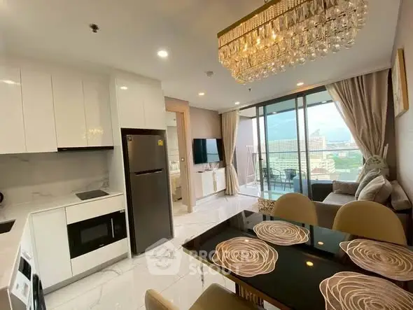 Luxurious open-plan kitchen and living room with elegant chandelier and city view balcony.
