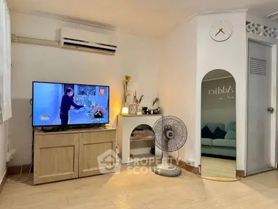 Cozy living room with TV, air conditioning, and stylish decor