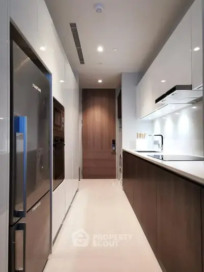 Modern kitchen with sleek cabinetry and stainless steel appliances in a contemporary apartment.