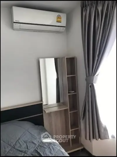 Cozy bedroom corner with air conditioning and stylish curtains