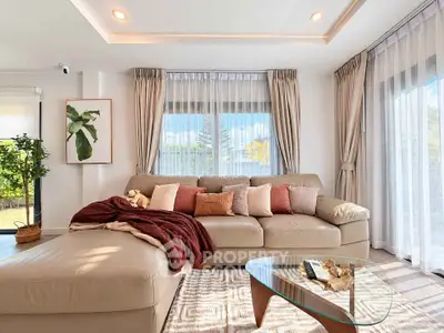 Luxurious living room with elegant decor and large windows offering natural light.