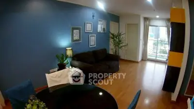 Stylish living room with blue accent wall and city view balcony in modern apartment.