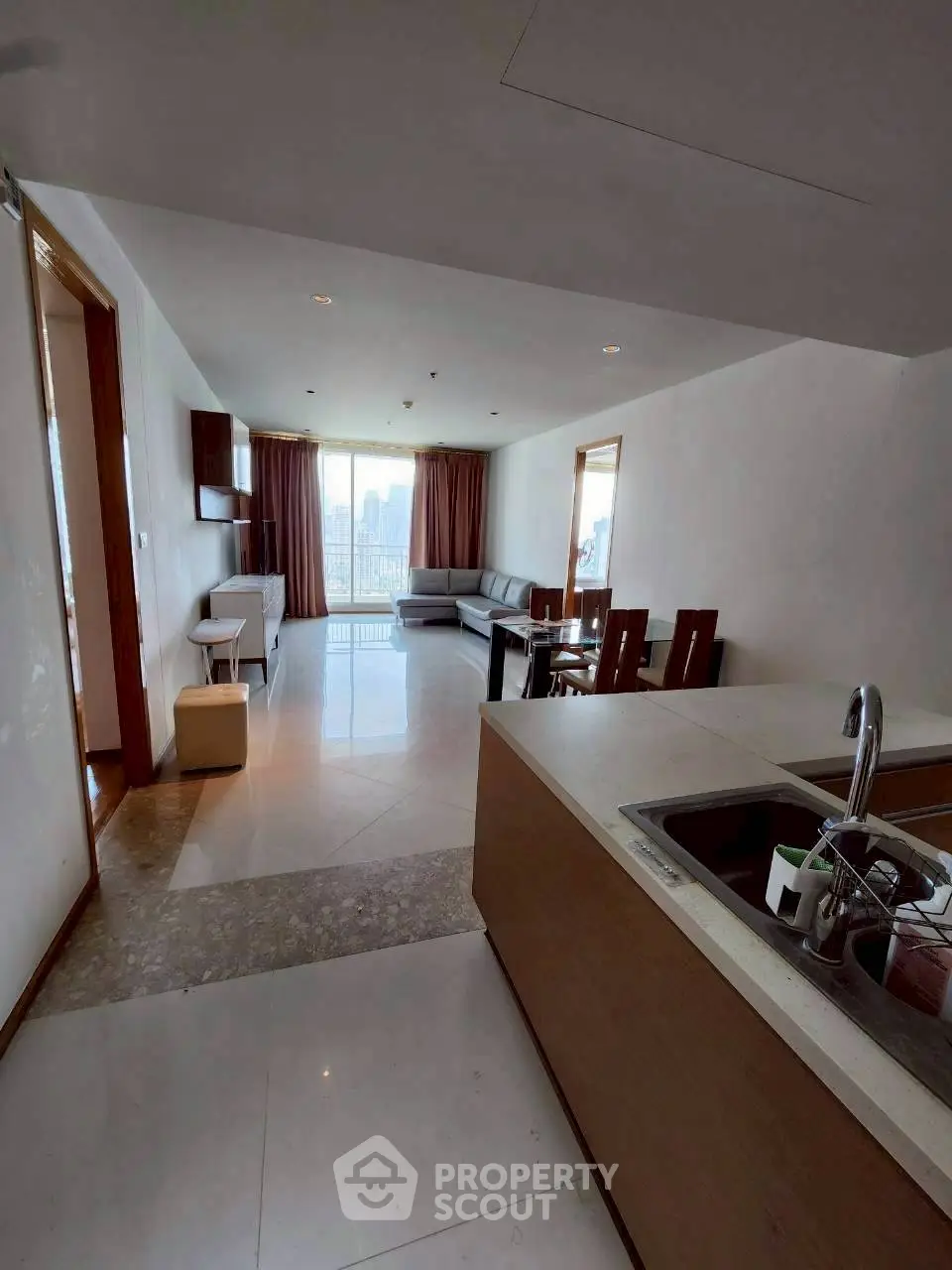 Spacious open-plan living room with city view and modern kitchen