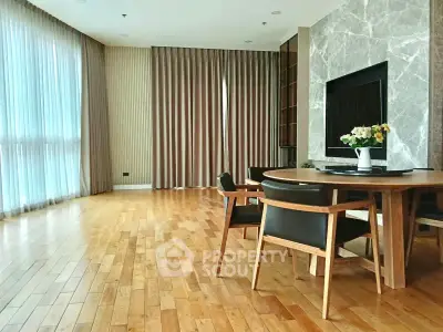 Spacious modern living room with elegant wooden flooring and large windows.