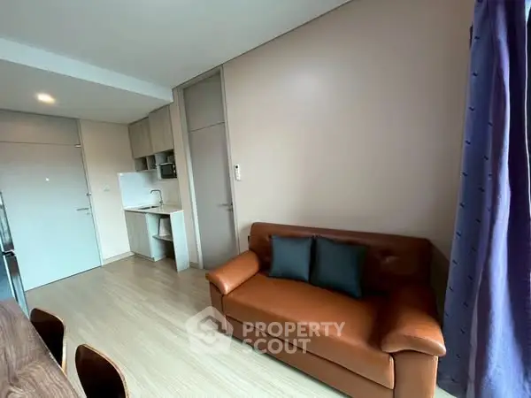 Modern living room with leather sofa and compact kitchen area
