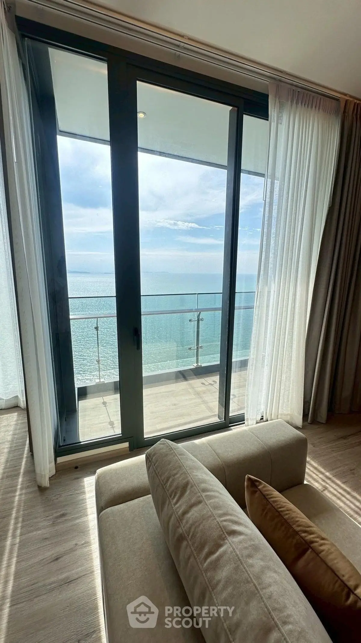 Luxurious living room with stunning ocean view from large balcony windows.