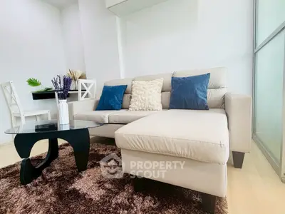 Modern living room with stylish beige sofa and glass coffee table