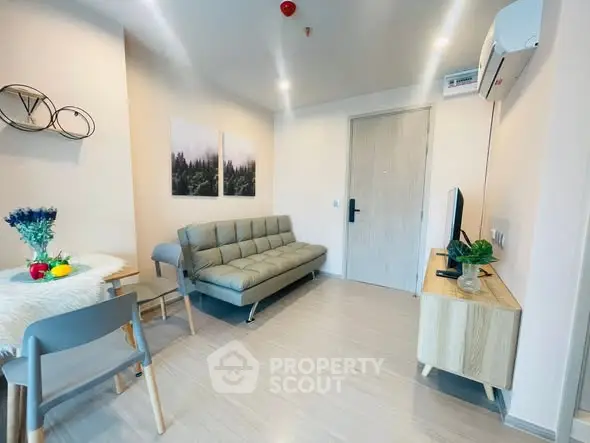 Modern living room with stylish furniture and decor, featuring a cozy sofa and wall art.