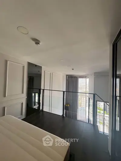 Modern bedroom with large windows and sleek design in a contemporary apartment.