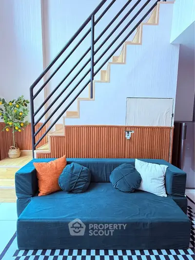Stylish modern living room with unique staircase and cozy sofa