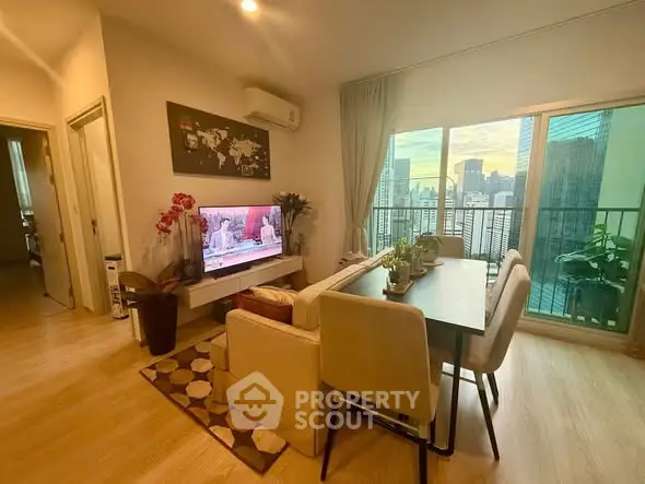 Modern living room with dining area and city view balcony in high-rise apartment.