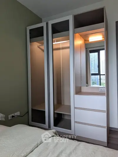 Modern bedroom with sleek wardrobe and city view, perfect for urban living.