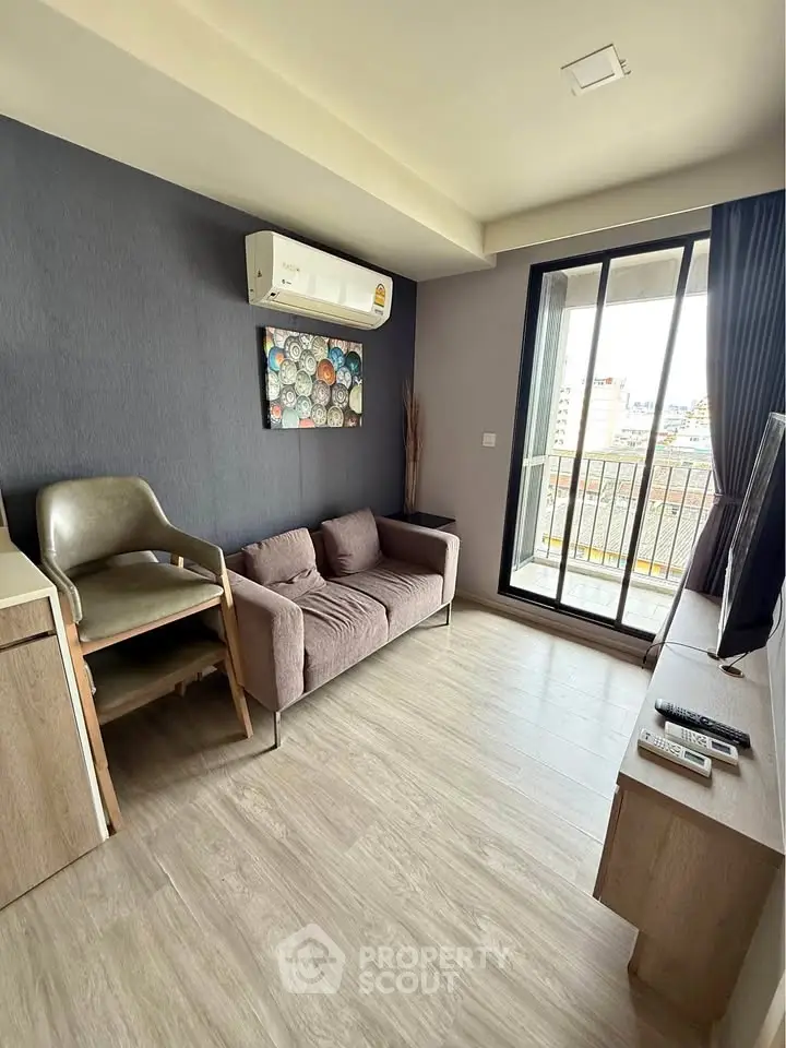 Modern living room with balcony access and stylish decor in urban apartment.