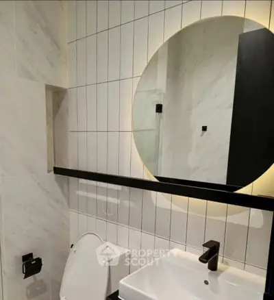 Modern bathroom with round mirror and sleek fixtures