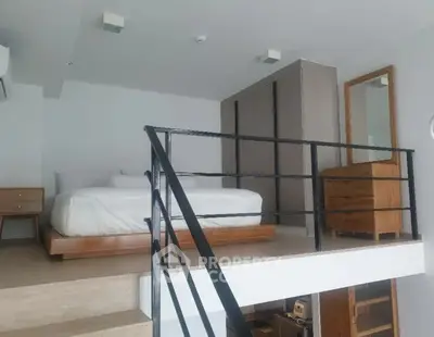 Modern loft bedroom with wooden furniture and sleek railing design
